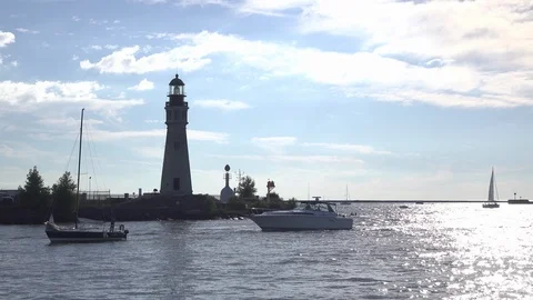 Boats coming into dock alongside light house in Buffalo New York 4k 스톡 동영상 99013840