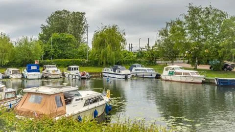 Boats of differing types and sizes line the banks of the River Great Ouse Stock Photos