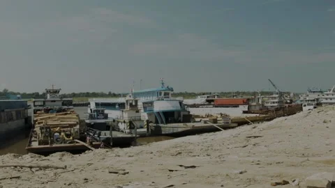 Boats on a dock of the Amazon river with a few people working in the back Stock Footage 188916322