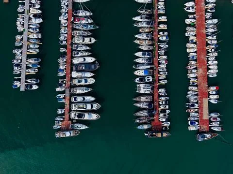 Boats docked at a marina during daytime in a coastal area with clear water .. Foto stock