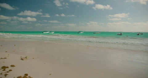 Boats float on turquoise water under cloudy sky at Playa Santa Fe Tulum Mexico Video stock 344914036