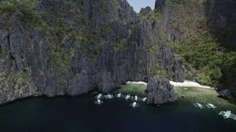 Boats in the lagoon by the Black Cliffs in the Philippines Stock Footage 273072189