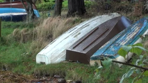 Boats lying upturned on the grass at the side of a Loch Stock Footage 44556040