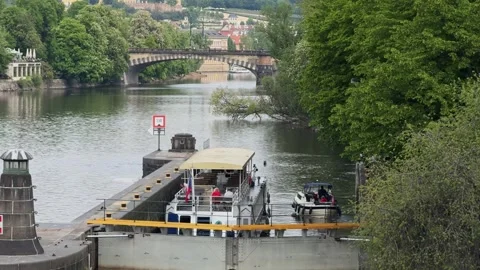 Boats navigate through the Mánes lock system on the Vltava River in Prague Stock Footage 342342103