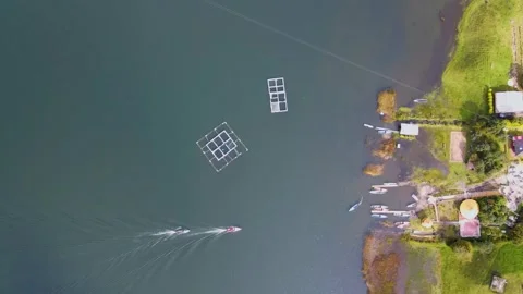 Boats navigating Cumbal Lagoon under clear skies Stock Footage 330983217