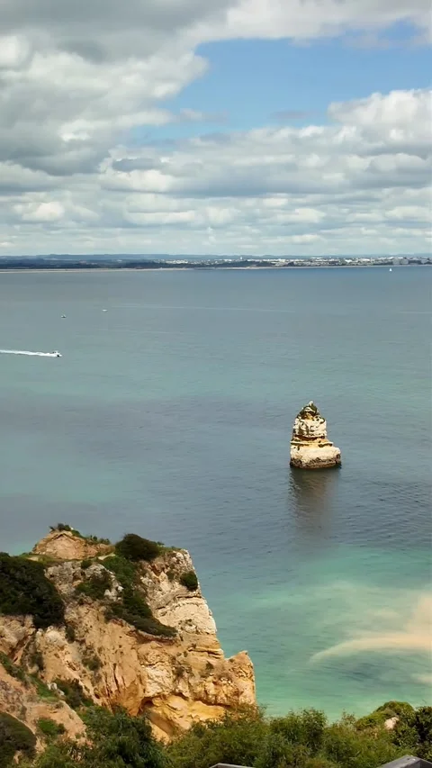 Boats Passing Close to Cliffs at Praia do Camilo Stirring Sandy Water, Lagos Stock Footage 334743580