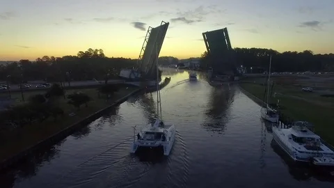Boats passing through draw bridge at sunrise 스톡 동영상 81257472