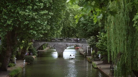 Boats passing under an old bridge on Utrecht's Oudegracht canal Stock Footage 340230481