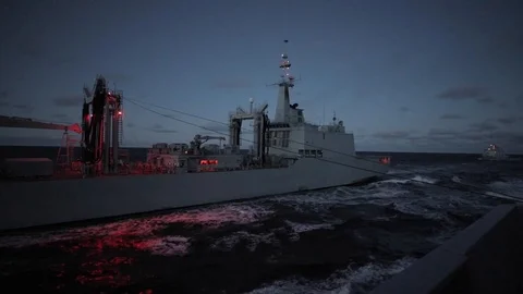 Boats prepare for connected replenishment method at night 1 Stock Footage 114084447