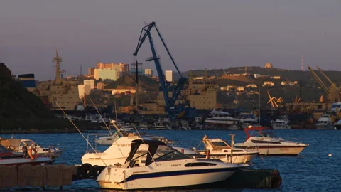 Boats rock on the waves of the sea in the light of the evening sun  Stock Footage 92205232