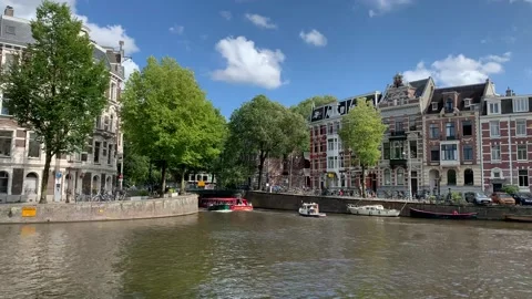 Boats sail under the bridge while tram passes the bridge. Amsterdam, Netherlands Stock Footage 249317704