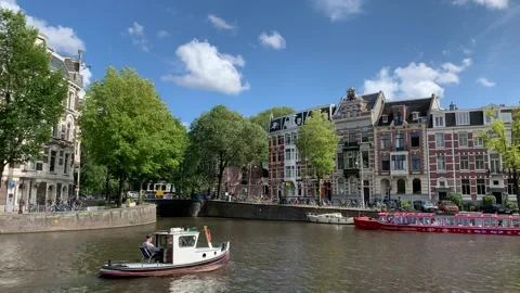 Boats sail under the bridge while tram passes the bridge. Amsterdam, Netherlands Stock Footage 249317705