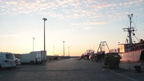Boats ships shipyard off coast dock at sunset sunrise with low sun shining Stock Footage 252153434