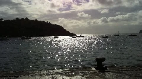 Boats on water backlit by cloudy sun setting Video stock 12518529