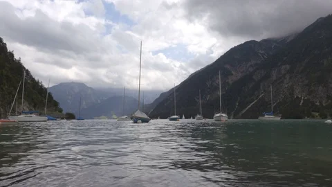 Boats on the waves in lake between the mountains in the rainy day Stock Footage 81931910