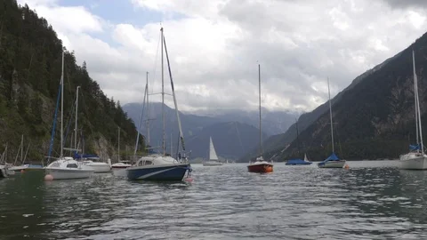 Boats on the waves in lake between the mountains in the cloudy day Stock Footage 81934751