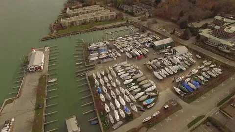 Boats wrapped up on stilts next to harbor drone aerial view Stock Footage 84144178