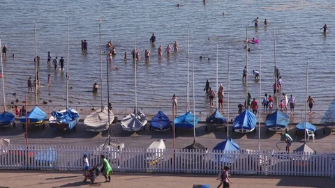 Boats, yachts and trailers lined up on Southend beach as people swim and play in Video stock 129344233