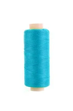 Bobbin with blue thread over white background 写真素材