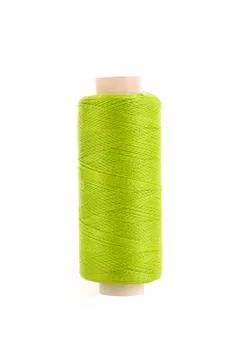 Bobbin with green thread over white background Фото