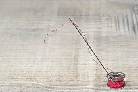 Bobbin needle and red thread Stock Photos