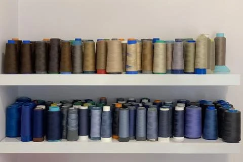 Bobbins with multi-colored sewing threads on a shelf Stock Photos