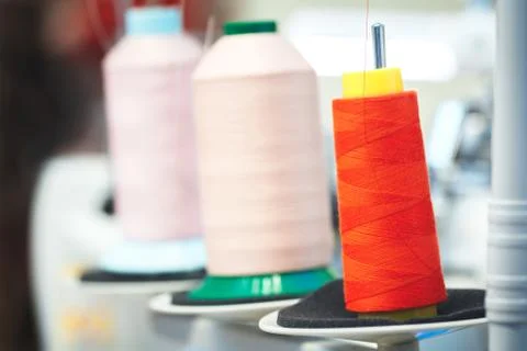 Bobbins with red and rose thread for industrial textile machines Foto stock