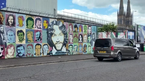 Bobby Sands Mural - Vehicles Passing Historic Belfast Peace Wall. Stock-Footage 338221686