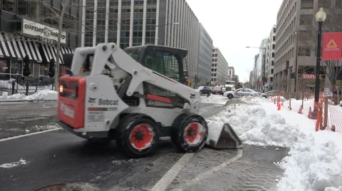 Bobcat front loader plows into snow, blizzard cleanup Stock Footage 59675667