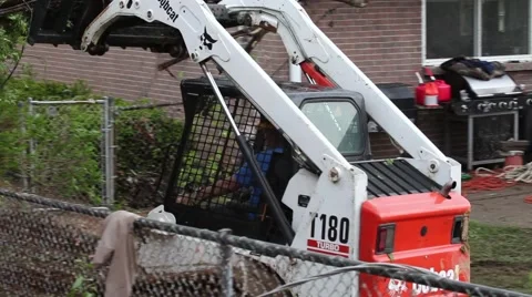 Bobcat Hauling Tree Trunks and Debris in Yard Stock Footage 45361030