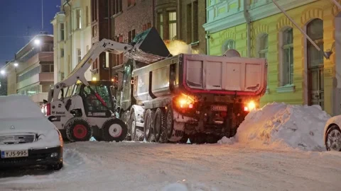 BobCat loader is uploading the snow to the truck Stock Footage 170458054