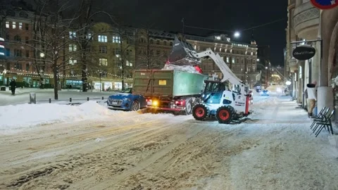 BobCat loader is uploading the snow to the truck Stock Footage 170458885