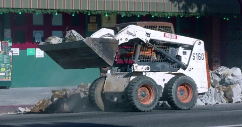 Bobcat skid loader earth mover tractor excavator working on road construction 4K Video stock 144664465