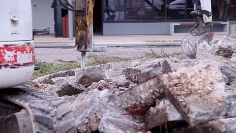 Bobcat tractor break down cement blocks with pneumatic hammer Hydraulic Breaker Stock Footage 71322226