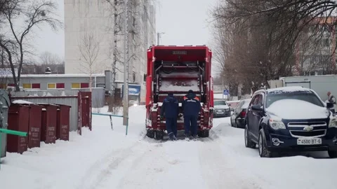 Bobruisk, Belarus - 12.02.23: Workers remove garbage from a trash can to a Stock Footage 293684529
