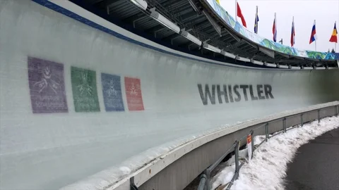 Bobsled passes 2010 Vancouver Olympic Sign in ice at Whistler Sliding Centre. Stock Footage 99248137