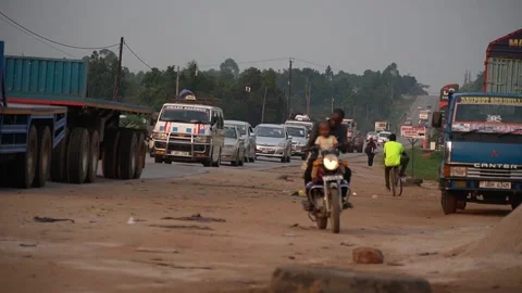 A boda-boda driver in Uganda with his child on the motorcycle. 스톡 동영상 322087158