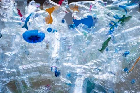 Bodegon of plastic bottles creating a sea with paper fish Stock Photos