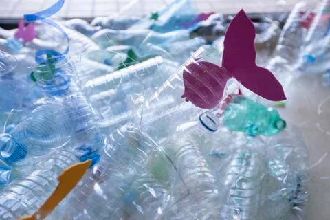 Bodegon of plastic bottles creating a sea with paper fish Stock Photos