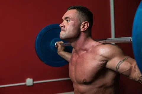 Body Builder doing squats with barbells Stock Photos