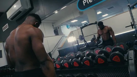 Body builder lifting heavy dumbbells in mirror in the gym Stock Footage 89577798