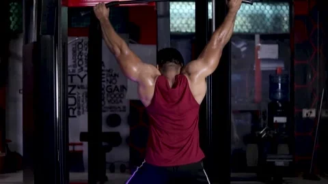 A body builder sweating in heavy weight shoulder workout on Cable Machine in gym Stock Footage 213288091