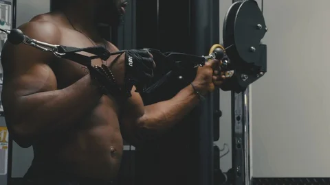 Body Builder uses cable machine cross over flies for building chest muscles Stock Footage 89578623