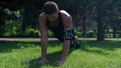 Body builder working out chest muscles in the park early in the morning Stock Footage 78926996