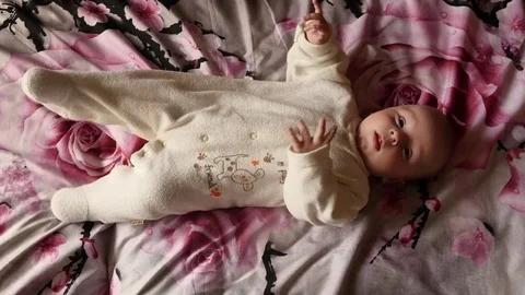Body motion of cute active few months old laying baby Stock Footage 75438026