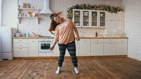 Body positive concept. Slow motion of happy overweight woman dancing at kitchen Stock Footage 143568002