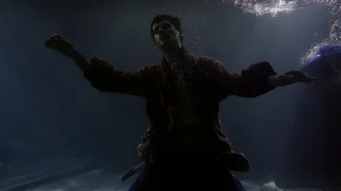 Body of sunken man is falling on bottom of river in darkness, mermaid is 스톡 동영상 105033817