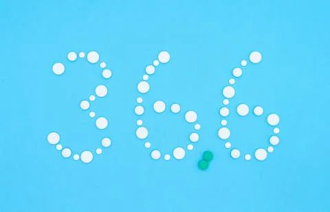 Body temperature value 36.6 lined with white pills on a blue background. Stock Photos
