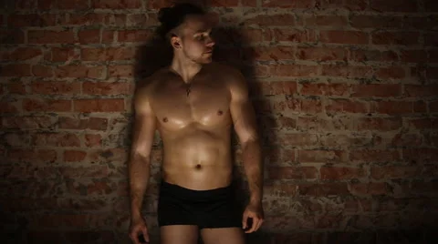 Bodybuilder against brick wall Stock Footage 63301195