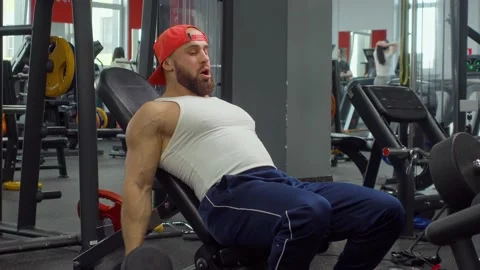 Bodybuilder bends his arms at the elbows with dumbbells and shakes his biceps 스톡 동영상 189950445